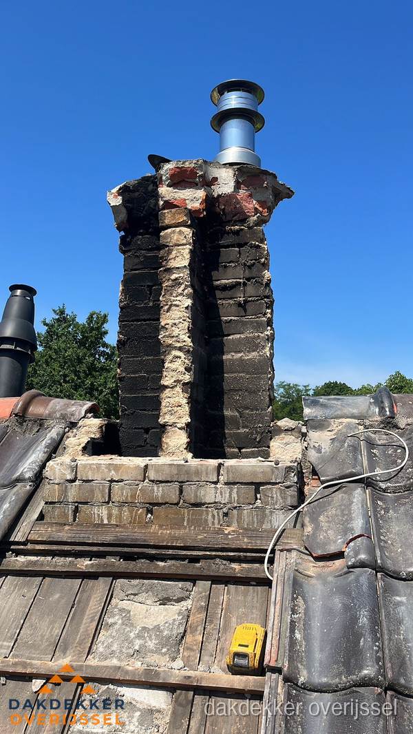 Beschadigde schoorsteen met nieuwe rookgasafvoer op oud dak in Overijssel