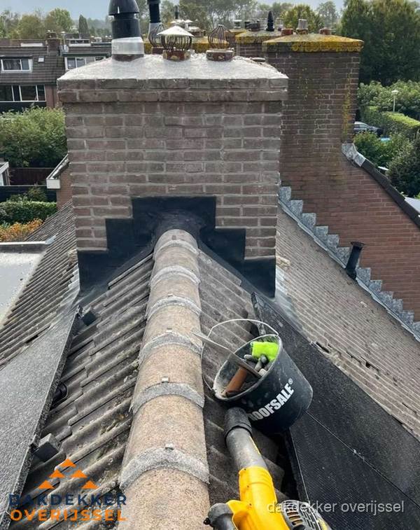 Schoorsteen met loodaansluiting en nokvorst op pannendak in Overijssel