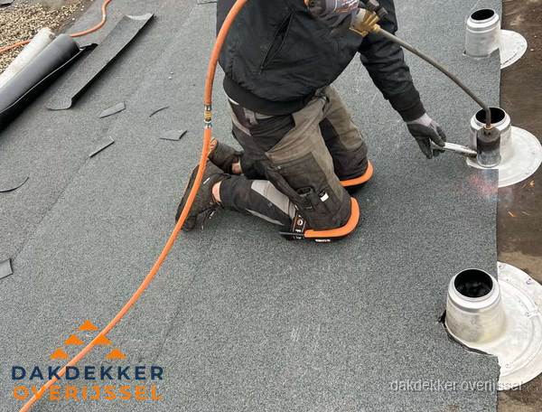 Dakdekker repareert bitumen dakleer bij dakdoorvoer in Overijssel