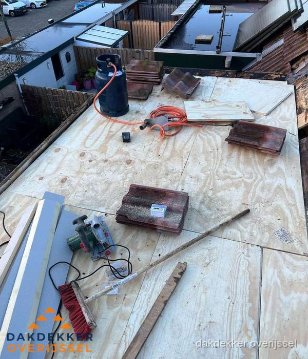 Dakreparatie werkzaamheden op plat dak met gereedschap in Overijssel