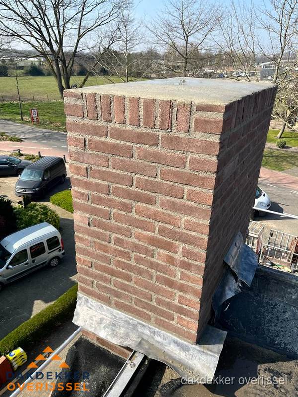 Gemetselde schoorsteen met loodaansluiting op dak in Overijssel