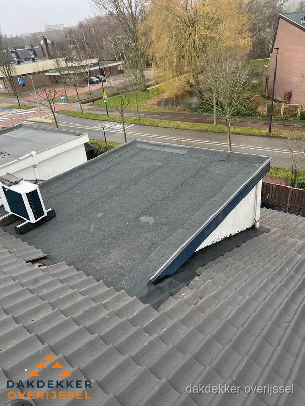 Plat dak met bitumen dakbedekking naast schuin pannendak in Overijssel