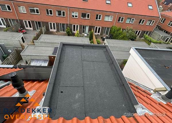 Plat dak met bitumen bedekking naast dakkapel in Overijssel