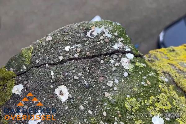 Beschadigde en verweerde nokvorst met scheuren en mos in Overijssel